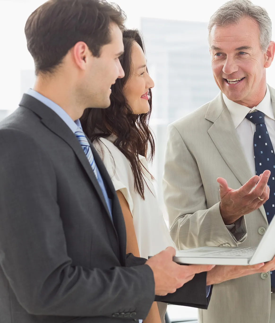 Portfolio managers in discussion over a laptop